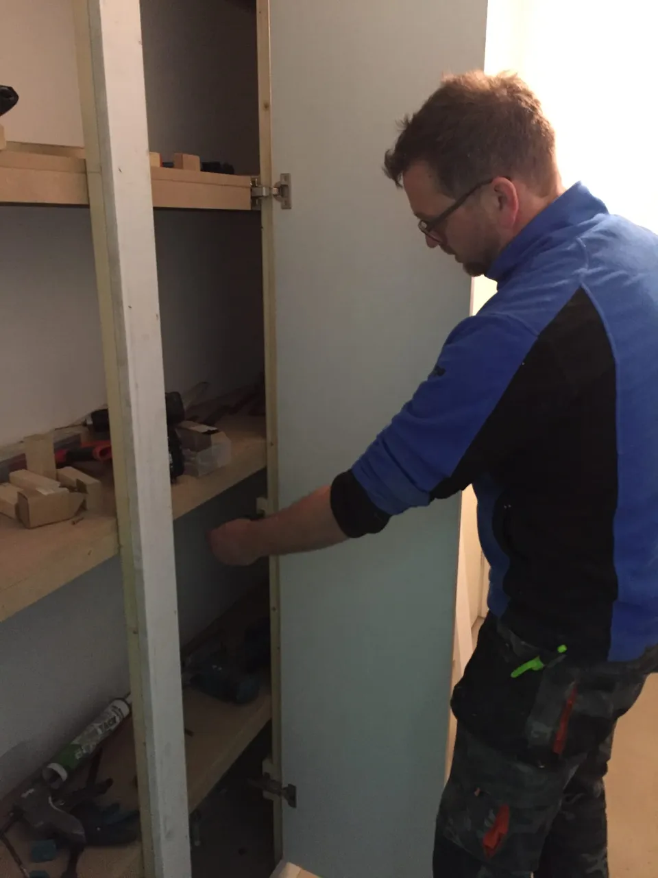 Daniel aan het werk aan een kast tijdens een renovatie