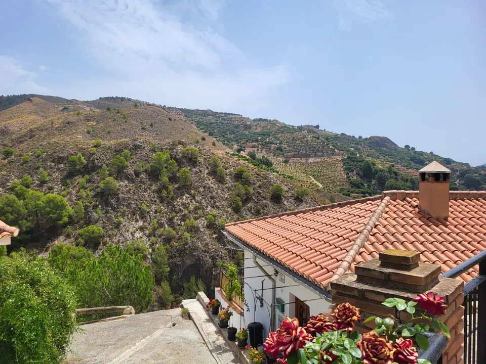Een huis met rode dakpannen in de bergen van Los Guájares
